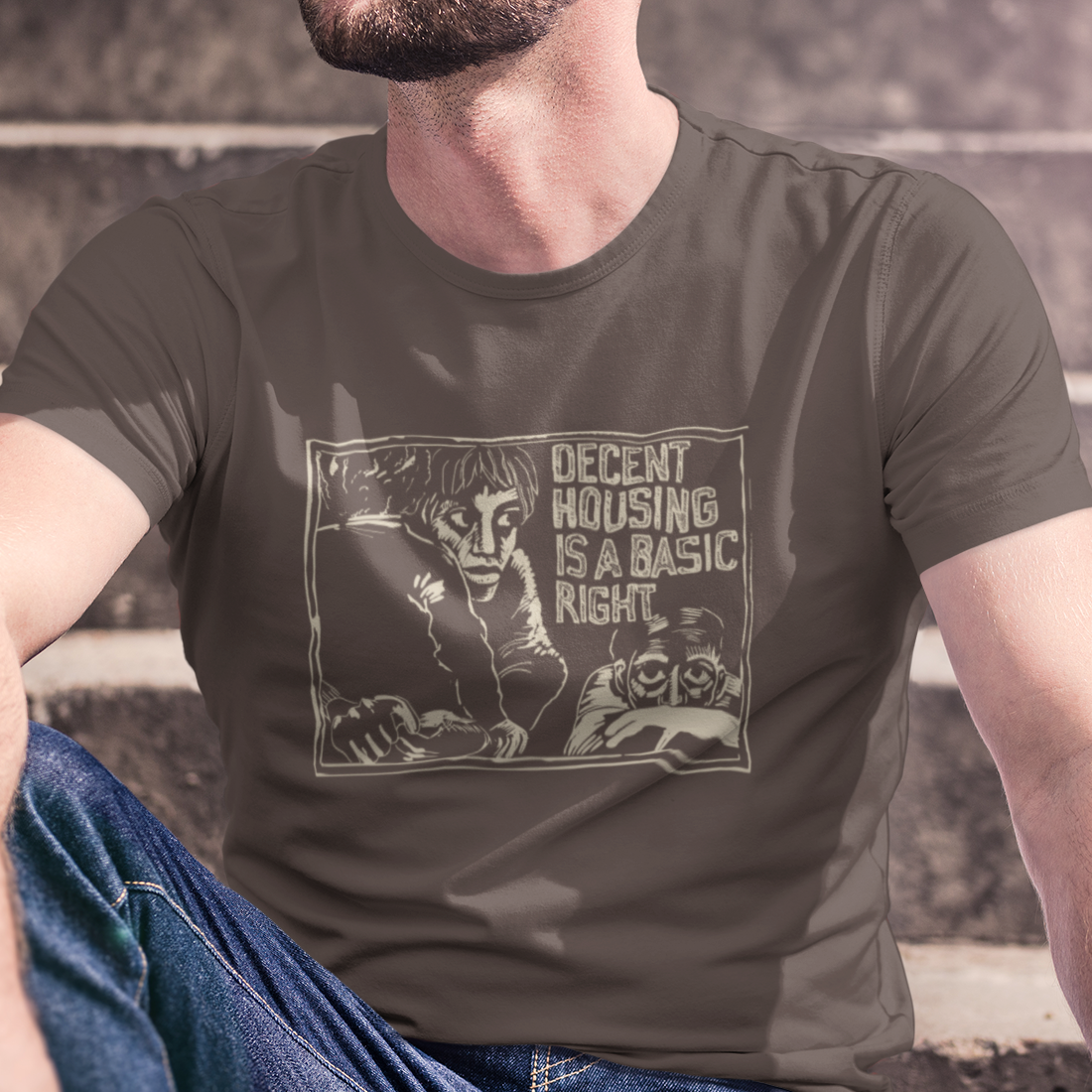 T-shirt with graphic of a poor family and 'decent housing is a basic right' text